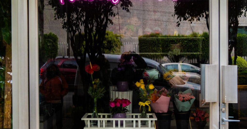 Neon sign 'Flowers are love' in a florist shop window, concepcion