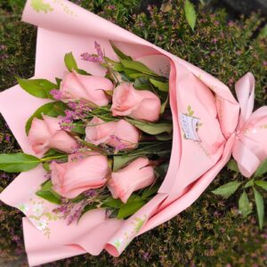 "Delicado ramillete de 6 rosas rosadas frescas envueltas en papel rosado con cinta. Servicio de flores a domicilio en Concepción por Naturaflor."