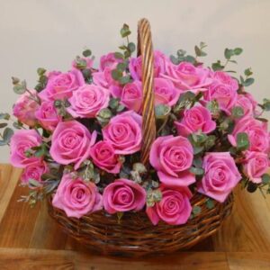 "Espectacular canasto de mimbre con 50 rosas rosadas frescas y follaje de eucalipto. Envío de flores a domicilio en el Gran Concepción por Naturaflor."